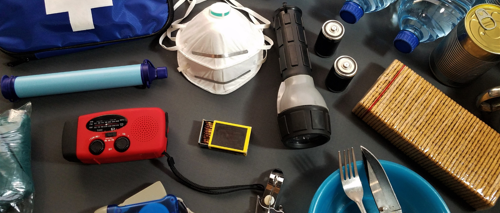 Emergency preparedness kit supplies including water, food, flashlight, radio, first aid kit, and other essentials